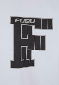 Balts audums ar lielu melnu grafisko burtu "F", kurā ir ģeometriski dizaina elementi. Logo ietver gaiši pelēkas kontūras un tekstu.