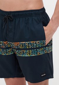 Juodos maudymosi šortai su elastinga juosmena, su spalvingu dryžuotu dizainu, mėlynos, oranžinės ir geltonos spalvų, per priekį.