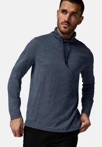 Camisa de hombre de manga larga gris oscuro con cuello alto y cordones, confeccionada en una tela suave de textura lisa. Detalle de logotipo sencillo en el pecho.