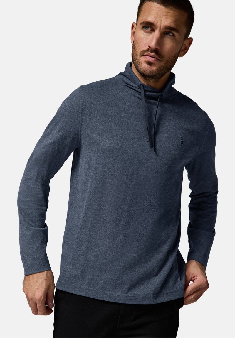 Camisa de hombre de manga larga gris oscuro con cuello alto y cordones, confeccionada en una tela suave de textura lisa. Detalle de logotipo sencillo en el pecho.