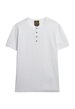 Biała krótko rękawowa koszulka wykonana z miękkiej bawełny, z okrągłym dekoltem i pięcioma czarnymi guziczkami na przedniej listwie.