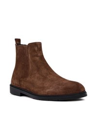 Stivale Chelsea in suede marrone con una texture liscia, pannelli laterali elasticizzati, punta rotonda e suola in gomma nera.