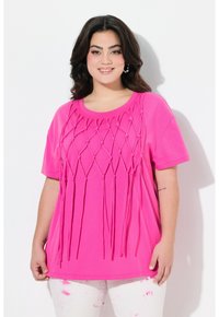 Camiseta de manga corta rosa con detalles tejidos y acentos anudados que cuelgan. Fabricada en material suave, con un corte relajado.