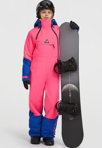 Felroze sneeuwpak met blauwe accenten, oversized pasvorm, voorzak, gecombineerd met een donkere snowboard met een maangrafiek en bindingen.