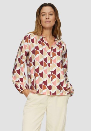 Blouse à manches longues et à boutons couleur crème avec un motif géométrique en bordeaux, rose clair et beige. Tissu léger avec des poignets de manches froncés.