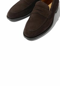 Brune ruskinds loafers med et slankt design, læderforing og diskret syninger. Har en rund toe og lav gummisole.