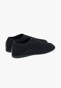 Czarne buty wsuwane z teksturowaną, plecioną cholewką, okrągłym noskiem oraz niskoprofilową gumową podeszwą. Gładkie akcenty na pięcie.