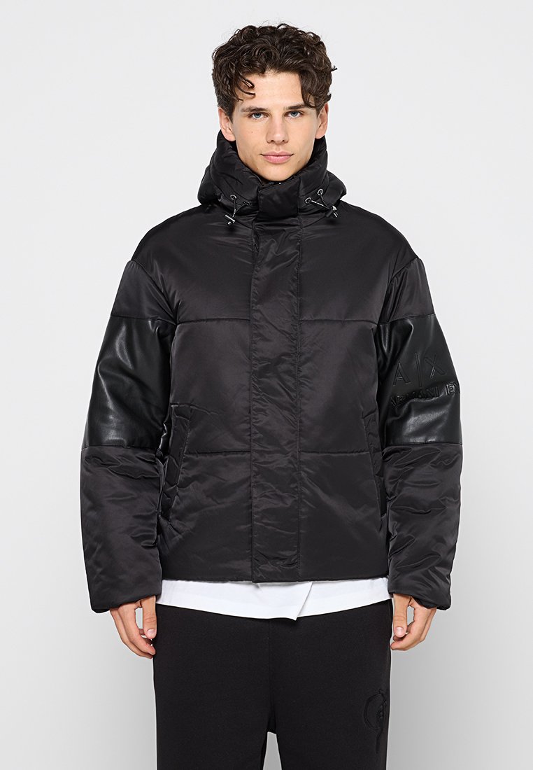 Giacca a vento nera con design trapuntato, collo alto, tasche frontali e maniche con dettagli in pelle. Realizzata in materiale resistente all'acqua.