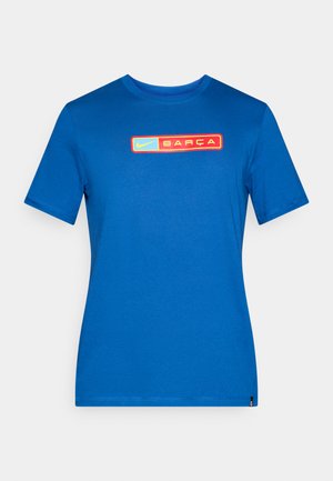 T-shirt azul de algodão com gola redonda. Apresenta um gráfico central com "Nike" e "BARÇA" em realces retangulares amarelos e vermelhos. Design simples.