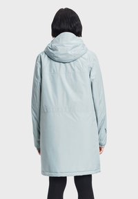 Giacca lunga con cappuccio di colore azzurro chiaro, caratterizzata da una texture liscia, polsi elasticizzati e una cucitura sul retro, adatta per un abbigliamento casual.