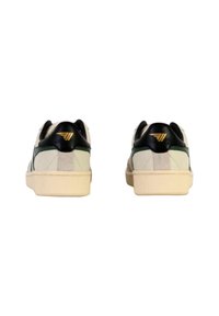 Sneakers with a white leather upper, black and green accents, and a beige sole. Displays logo detail on the heel and minimalist design.