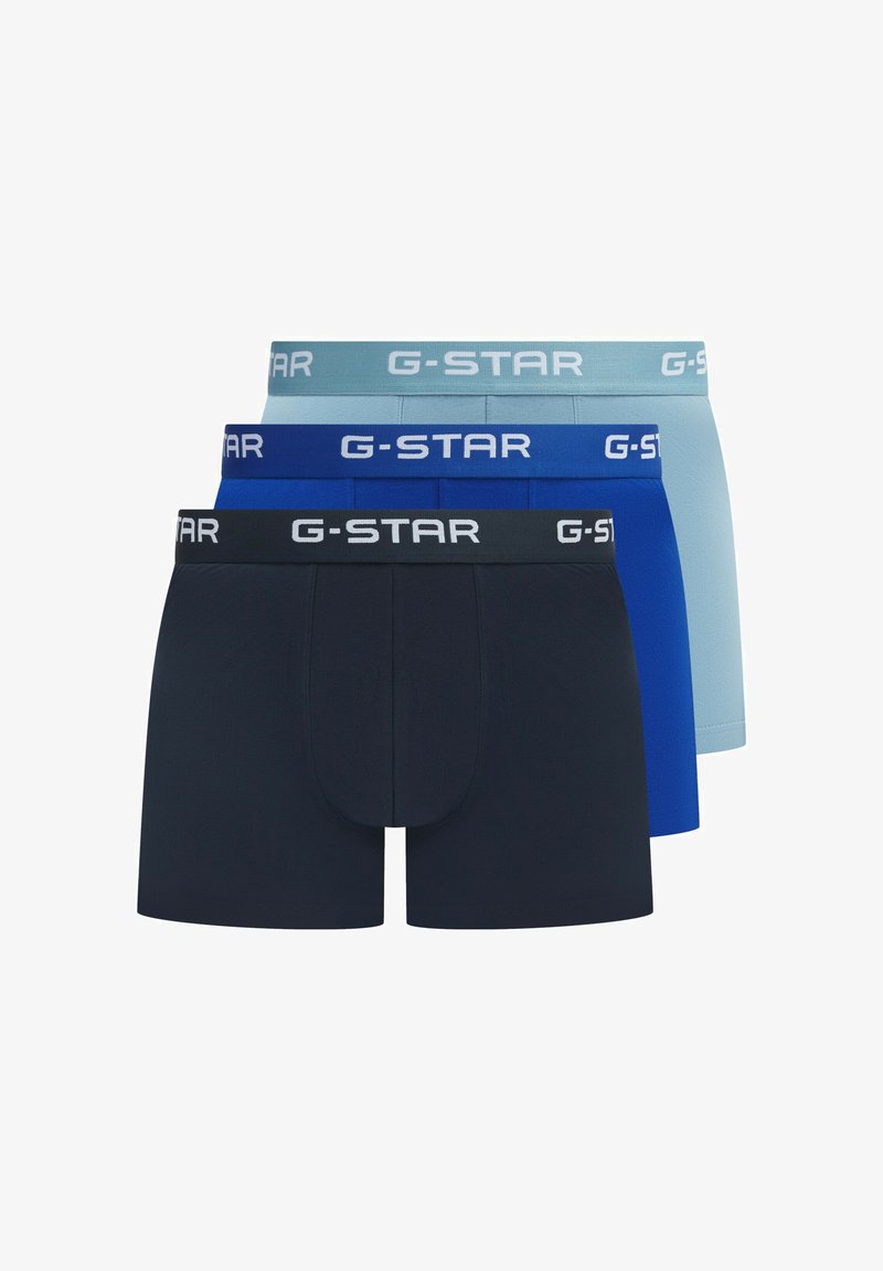Drie paar G-Star boxershorts in donkerblauw, blauw en lichtblauw, met merkgebonden elastische taillebanden en een nauwsluitend ontwerp.