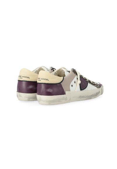 Leren sneakers in beige en donkerpaars. Beschikt over een gemêleerd ontwerp, vetersluiting en een versleten rubberen zool. Merken op de hiel.