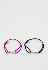 Deux bracelets ajustables : l'un en rose vif et l'autre en noir, tous deux ornés d'un logo "HUGO" en ton argent et d'un design minimaliste.