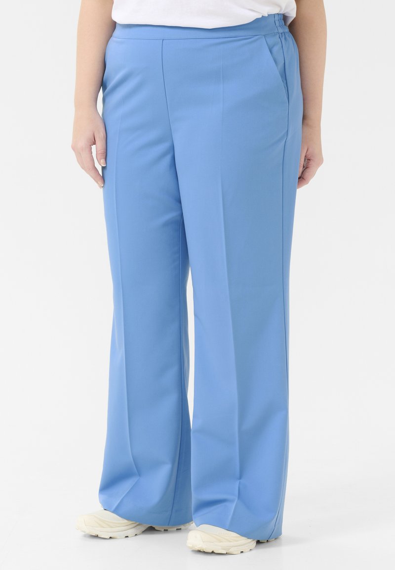 Light blue trousers made of a smooth fabric, featuring a straight-leg design with side pockets and an elasticated waistband.