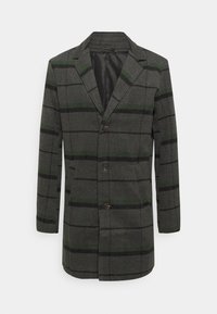 Grå blazer med sjakkmønster, med grønne og svarte striper. Laget av stoff med en glatt tekstur, inkluderer to-knapps lukking og lommer.