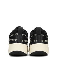 Zapatillas negras con tejido texturizado y cuero, con costuras blancas en contraste y una suela gruesa. Tirador en la parte trasera para facilitar su uso.