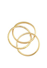 Tre guld ringe, der overlapper, med varierende tykkelse og finish. Én har en struktureret overflade, mens de andre er glatte og polerede.