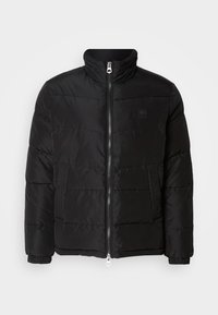 Chaqueta acolchada negra con cuello alto, cierre de cremallera y detalles de costura horizontal. Presenta un panel lateral texturizado y puños elásticos.