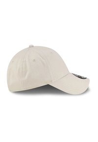 Jasno beżowa czapka baseballowa z sześcioma panelami, z wentylacyjnymi otworami i zakrzywionym daszkiem, pokazana z boku na białym tle.