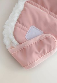 Pink winter mittens featuring a soft, fluffy interior lining, smooth exterior fabric, and stitched detailing at the cuff and seam.