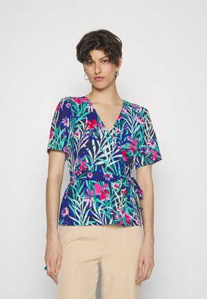 Blusa floral envolvente com decote em V profundo, mangas curtas e cintura com laço. As cores dominantes incluem azul marinho, rosa, verde e branco.