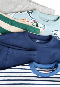 Cinq chemises à manches courtes empilées : tissu côtelé gris, bleu à rayures blanches, imprimé graphique coloré, rayé vert et bleu marine uni.