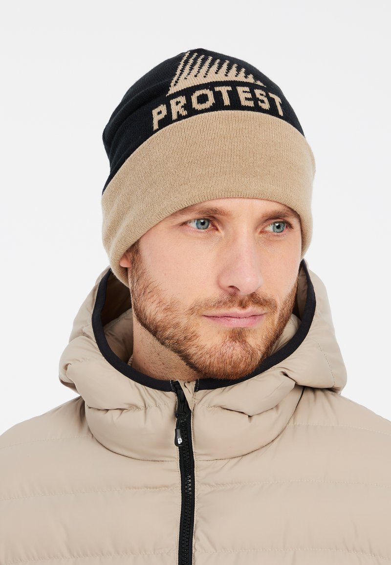 Gebreide beanie in zwart en beige met 'PROTEST' logo; zachte textuur, meerkleurig ontwerp. Opgeblazen bomberjack met capuchon in neutraal beige.