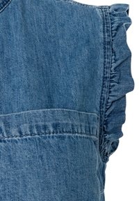Blauwe denimstof met een gerimpelde randdetail langs een kledingnaad, toont textuur en stiksels van dichtbij.