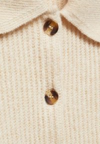 Maglione polo a maglia beige con tessuto texture, design a coste e accenti di bottoni marroni a contrasto con finitura marmorizzata.
