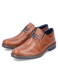 Scarpe in pelle marrone con finitura liscia, design con lacci, punta rotonda, dettagli blu e una sezione testurizzata sul lato. Suola in gomma.