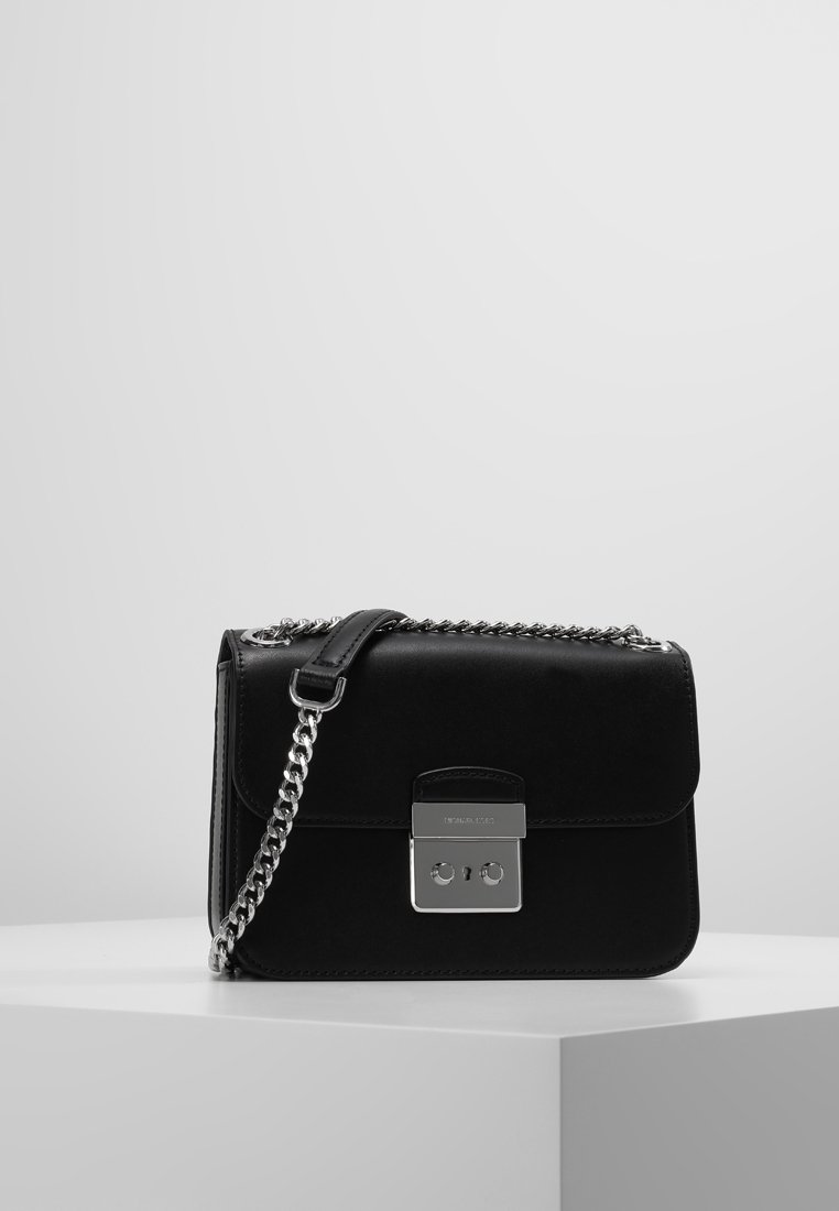 Borsa a tracolla in pelle nera con catena in tono argento, forma rettangolare, chiusura a patta e dettagli in metallo sulla parte anteriore.