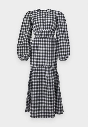 Vestido a cuadros en blanco y negro con mangas largas abullonadas, cintura ceñida y falda en capas. Fabricado en tejido ligero. Escote redondo.