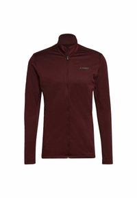 Chaqueta de cremallera color burdeos con cuello alto, mangas largas y tejido texturizado. Presenta un pequeño logo gris en el pecho. Cierre frontal de cremallera.