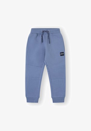 Pantalones de chándal azules, hechos de material suave, con una cintura ajustable por cordón, puños acanalados y un bolsillo lateral con un parche de logo. Diseño texturizado.