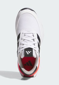 White sneaker with black stripes. Features a textured upper, white laces, and a black heel tab with logo. Bright red interior and padded collar.