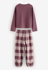 Top a maniche lunghe in malva, abbinato a pantaloni a righe di crema e malva scuro. I pantaloni presentano una vita elastica e polsini affusolati.