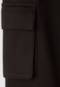 Szczegół czarnej tkaniny kieszeni od odzieży. Tekstura jest gładka, z widocznym szwem i klapką, co tworzy uporządkowany wygląd.