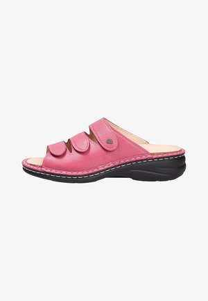 Pink leather slide sandal with three adjustable straps, open toe design, and black rubber sole featuring white stitching details.