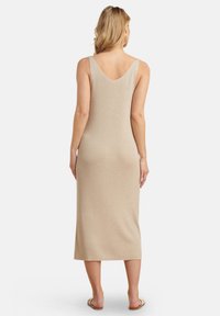 Knielanges, ärmelloses Kleid in einem hellen, metallischen Goldton, das einen V-Ausschnitt am Rücken aufweist und eine figurbetonte Silhouette mit einer glatten, dehnbaren Struktur hat.