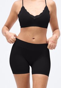 Haut court noir et short taille haute en matière élastique lisse, avec une bordure en dentelle sur le haut et un design élégant et ajusté.