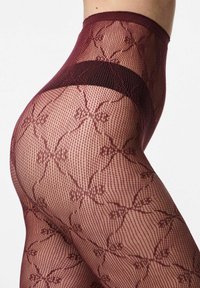 Bordeauxrøde netstrømper med blomstermønster, der har en glat, ensfarvet linning og indviklede detaljer i hele mesh-designet.