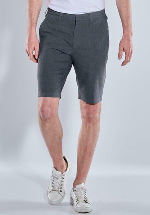 Gray shorts made of a textured fabric, featuring a straight cut and a short length, paired with white sneakers.
