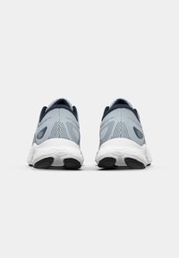 Light grey athletic shoes with mesh upper, contrasting dark blue accents, and white textured outsole. Features padded ankle collar and heel.