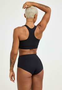 Zwart sportief crop top en high-waisted slips, gemaakt van een gladde stof, met een racerback ontwerp en minimale stiksels.