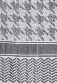 Tissu avec des motifs pied-de-poule et zigzag dans des nuances de gris. Tissage texturé avec des lignes horizontales et verticales. Design structuré.