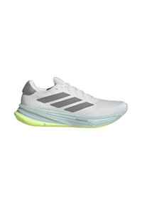 Zapatilla deportiva blanca con rayas grises, parte superior texturizada, suela acolchada de color verde claro y etiqueta "DREAMSTRIKE" en el lateral.