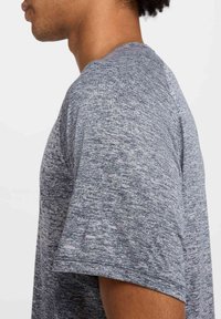 Camiseta de manga corta gris jaspeada con escote redondo. Tejido suave y texturizado con un corte casual y mínimas costuras.