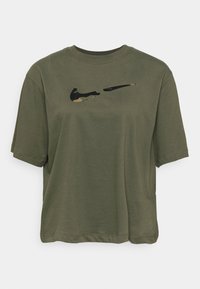 Camiseta de manga corta verde oliva hecha de algodón suave, con un logotipo de Nike en negro y camuflaje impreso en el pecho. Diseño de corte relajado y cuello redondo.