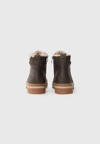 Brune læder ankboots med et faux fur-for, glat tekstur, lynlås bagpå og lysebrune gummisåler med præget branding.